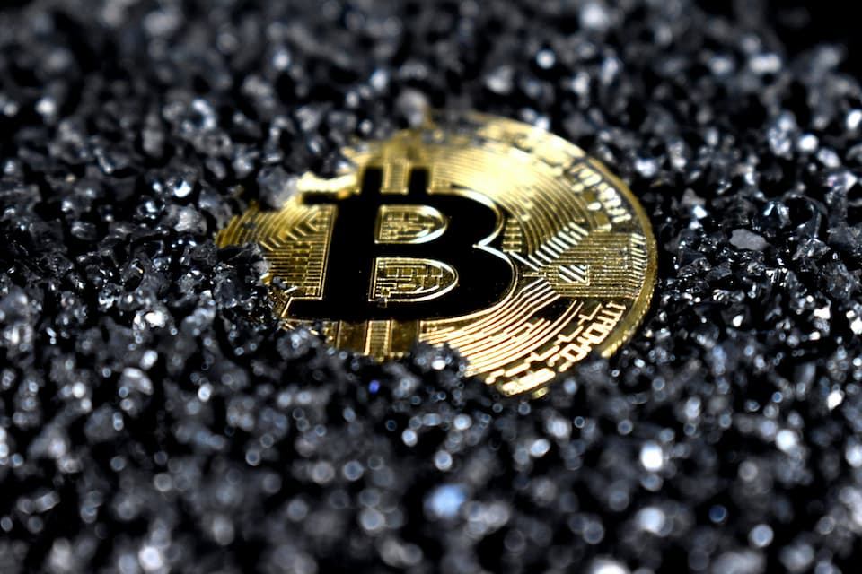 Gold Bitcoin on a black surface.
